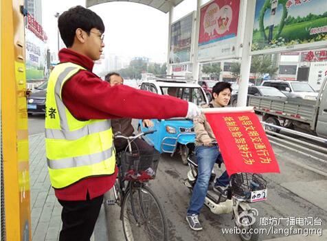 圖為安利志愿者在市區(qū)金光道和新華路交口協(xié)助交警維護(hù)交通