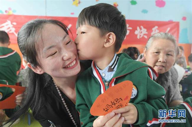 5月10日，在湖北省襄陽(yáng)市一家幼兒園舉辦的母親節(jié)主題活動(dòng)中，一名小朋友將自己制作的賀卡獻(xiàn)給媽媽。 新華社發(fā)（安富斌 攝）